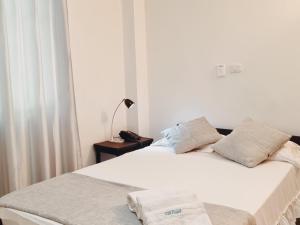 巴兰卡韦梅哈K12 Hotel的卧室配有白色床和毛巾