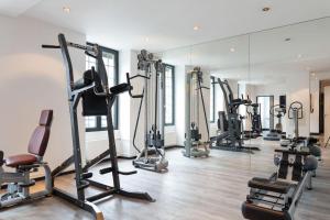 于尔亚日莱班Grand Hôtel & Spa Uriage的健身房设有数台跑步机和镜子