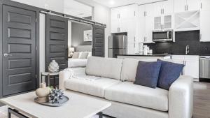 迪凯特Landing Modern Apartment with Amazing Amenities (ID1208X667)的一间带白色沙发的客厅和一间厨房