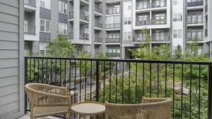 迪凯特Landing Modern Apartment with Amazing Amenities (ID1208X667)的阳台配有两把椅子和一张桌子,公寓大楼