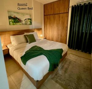 An NakhlahElite Residence - Furnished Apartments的一间卧室配有一张带绿毯的床