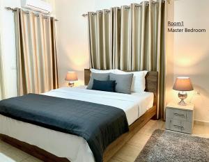 An NakhlahElite Residence - Furnished Apartments的一间卧室配有一张大床、两盏灯和一个窗户。