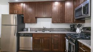 洛杉矶Landing Modern Apartment with Amazing Amenities (ID8735X33)的厨房配有木制橱柜和不锈钢冰箱。