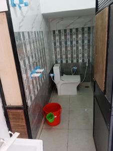 马图拉OP Krishna Homestay的一间带卫生间和桶的小浴室