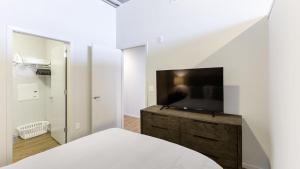 奥马哈Landing Modern Apartment with Amazing Amenities (ID9106X83)的一间卧室配有一张床和一台平面电视