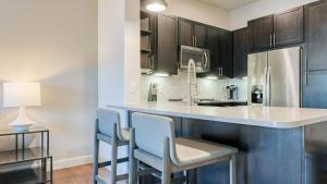 休斯顿Landing Modern Apartment with Amazing Amenities (ID1413)的厨房配有带椅子的柜台和冰箱。