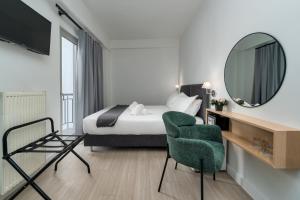 雅典Hotel Adonis Athens的一间卧室配有一张床、镜子和椅子