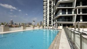 迪拜EasyGo - Binghatti Luna Stylish 1BR的一座高楼旁边的大型游泳池