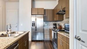 欧文Landing Modern Apartment with Amazing Amenities (ID9245X93)的厨房配有不锈钢冰箱和木制橱柜