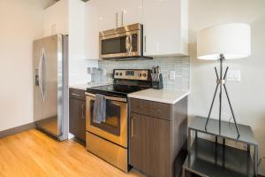 丹佛Landing Modern Apartment with Amazing Amenities (ID1959)的厨房配有炉灶和不锈钢冰箱。
