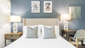 夏洛特Landing Modern Apartment with Amazing Amenities (ID9577X84)的卧室配有一张带两盏灯的白色床和一张书桌。