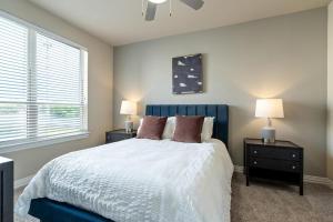 卡罗尔顿Landing Modern Apartment with Amazing Amenities (ID3876)的一间卧室配有一张蓝色的床,配有两个床头柜和两盏灯