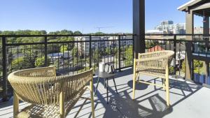 格林维尔Landing Modern Apartment with Amazing Amenities (ID1228X214)的阳台配有2把椅子和1张桌子