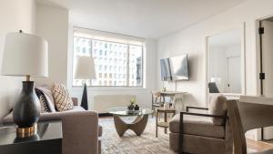 纽约Landing Modern Apartment with Amazing Amenities (ID3117X83)的客厅配有沙发和桌子