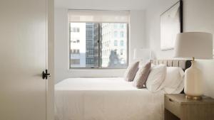 纽约Landing Modern Apartment with Amazing Amenities (ID3117X83)的卧室配有白色的床和窗户