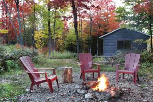 FramptonChalet Chic Shack - Un endroit paisible的院子里坐在火炉边的三把椅子