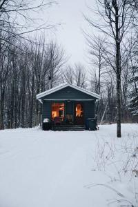 FramptonChalet Chic Shack - Un endroit paisible的雪中的小房子,灯火通明