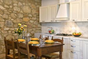 瓜尔迪斯塔洛Podere La Querciola的厨房配有木桌、椅子和桌子。