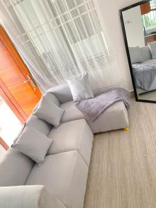 达累斯萨拉姆LuckySmallie 1-Bed Apartment in Goba Dar es Salaam的带沙发和镜子的客厅