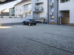 奥西耶克APARTMANI INFINITY的停在大楼旁边的停车场的汽车
