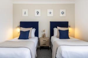 雷德鲁斯Inn For All Seasons的蓝色和白色的客房内的两张床