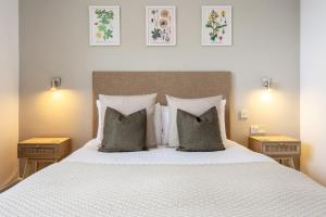 雷德鲁斯Inn For All Seasons的卧室配有白色的床、枕头和2张桌子