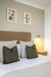 雷德鲁斯Inn For All Seasons的一间卧室配有一张带绿色枕头的床