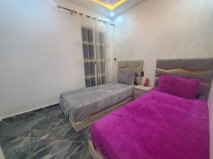 舍夫沙万Dar Brahim的紫色床单的客房内的两张床
