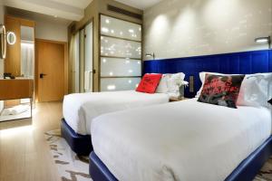 马德里Hard Rock Hotel Madrid的酒店客房带两张床和一间浴室
