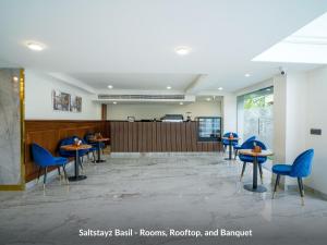 古尔冈Saltstayz Basil - Near Golf Course Road & Extension Road的一间设有蓝色椅子和桌子的等候室