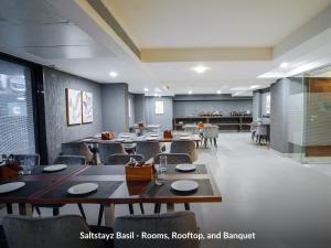 古尔冈Saltstayz Basil - Near Golf Course Road & Extension Road的餐厅内带桌椅的用餐室