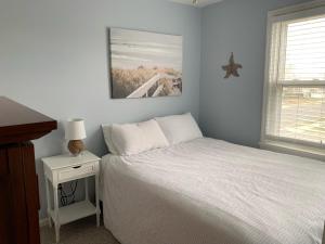 布拉德利比奇Bradley Beach Cozy Retreat的卧室配有白色的床和带床头柜的卧室