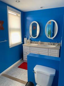 布拉德利比奇Bradley Beach Cozy Retreat的蓝色的浴室设有两个盥洗盆和一个卫生间