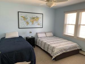布拉德利比奇Bradley Beach Cozy Retreat的卧室配有两张床,墙上挂有地图