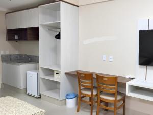 卡达斯诺瓦斯Spazzio Diroma, C - Acesso Ao Acqua Park的厨房配有白色橱柜、2把椅子和1台电视