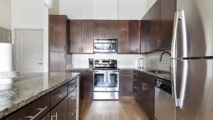奥兰多Landing Modern Apartment with Amazing Amenities (ID1019X387)的厨房配有木制橱柜和不锈钢冰箱。