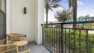 奥兰多Landing Modern Apartment with Amazing Amenities (ID1019X387)的阳台配有两把椅子、围栏和棕榈树