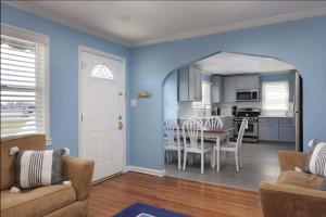 希塞德高地Island Time- beautifully renovated bay view home的一间厨房和带蓝色墙壁及桌子的用餐室