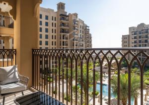 迪拜Madinat Jumeirah Living 1 Bed Pool and Garden View的享有游泳池和建筑景致的阳台