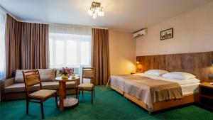 沃罗涅什Отель Ямской的酒店客房配有床、沙发和桌子。