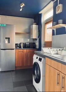 伦敦Entire 2 bedroom house in Hackney的厨房配有洗碗机、洗衣机和烘干机。