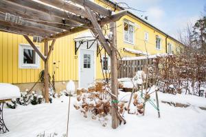 斯德哥尔摩Retro Retreat with Modern Comforts的前面有雪的黄色房子