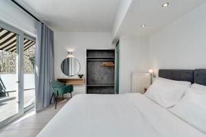 雅典Hotel Adonis Athens的卧室配有一张白色大床和一张书桌