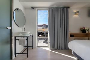 雅典Hotel Adonis Athens的一间卧室配有床、水槽和镜子
