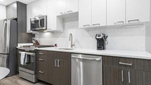 阿林顿Landing Modern Apartment with Amazing Amenities (ID8363X48)的厨房配有不锈钢用具和白色橱柜