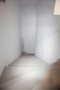 洛加拉斯Paros Melodia Apartments的白色墙壁的空房间中的楼梯