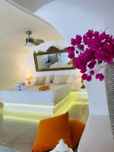伊亚棕榈树小山别墅的一间卧室配有一张床和一个紫色花瓶