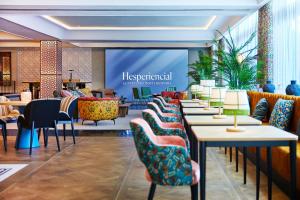 塞维利亚塞维利亚赫斯珀里亚酒店的餐厅设有一排桌椅