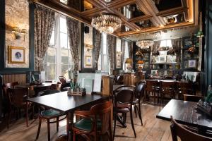 格伦里丁The Ullswater Inn- The Inn Collection Group的餐厅设有桌椅和窗户。
