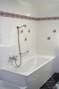KottmarsdorfFerienwohnung Kottmarsdorf的浴室设有带淋浴的白色浴缸。